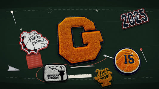 Chenille varsity letter and award patches laid out with a needle, thread, pins and ruler ready to be sewn onto a letterman jacket
